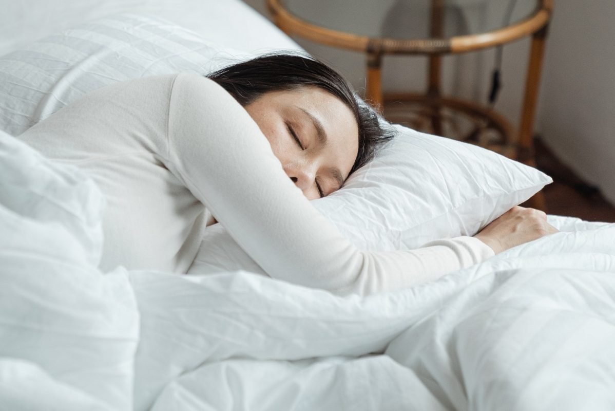 Woman Sleeping in White Bedding