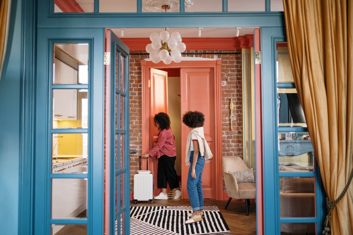 Women with luggage in an apartment hallway